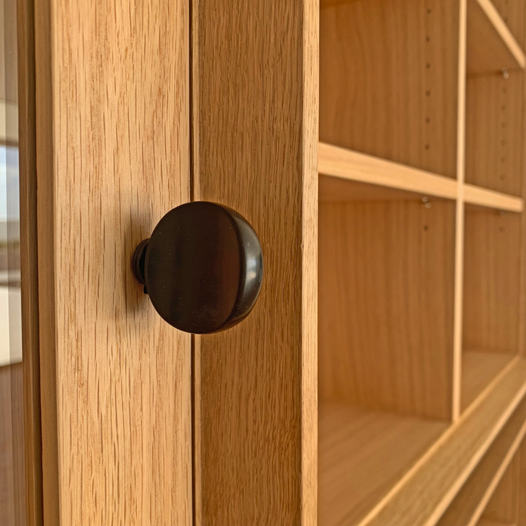 Ebony key on a hinged door on Oak wall unit